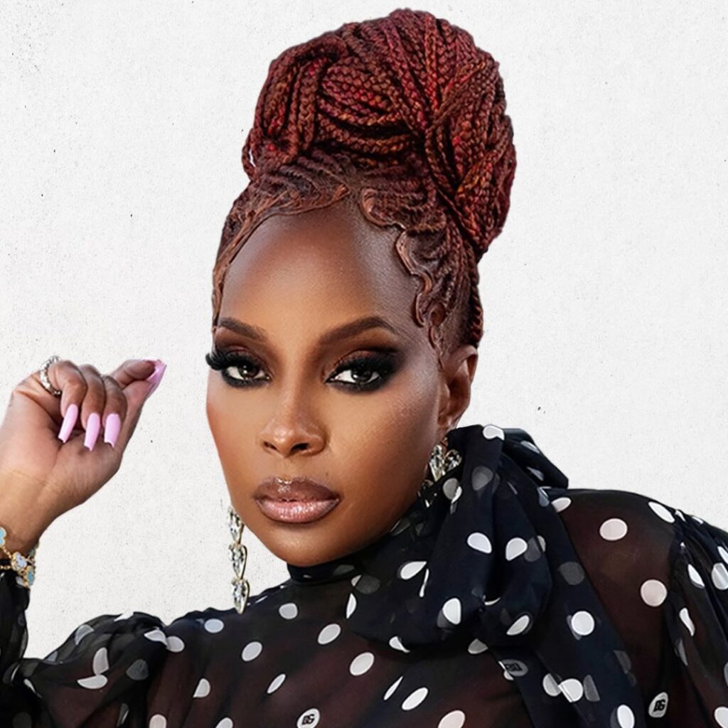 Portrait of Mary J. Blige wearing an elegant black strapless dress and a luxury diamond statement necklace, featuring a signature blonde precision bob hairstyle.