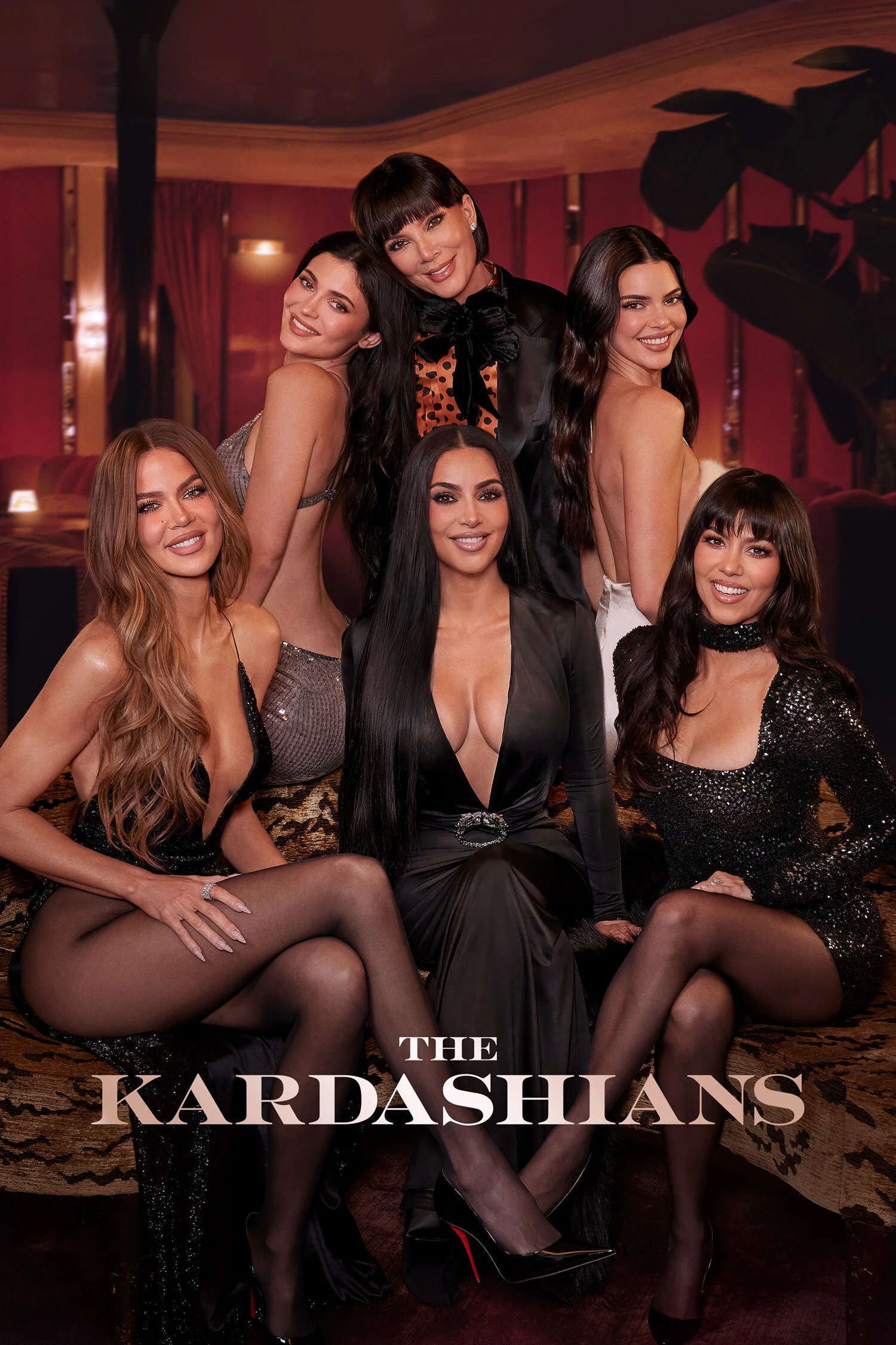Promotional poster for The Kardashians TV show featuring Khloé Kardashian, Kylie Jenner, Kris Jenner, Kim Kardashian, Kendall Jenner, and Kourtney Kardashian in elegant dark evening wear in a warm lounge setting.